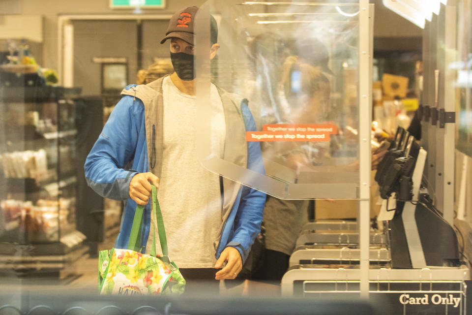 SYDNEY, AUSTRALIA - JANUARY 03: Shoppers are seen at a partitioned  supermarket checkout at The Corso in Manly on January 03, 2021 in Sydney, Australia. Face masks are now compulsory in certain indoor settings across NSW as the state continues to record new COVID-19 cases in the community. As of midnight, face masks are mandatory on public transport, in retail shops and supermarkets, indoor entertainment including cinemas and theaters, places of worship and hair and beauty premises. Face masks are also mandatory for all staff in hospitality venues and casinos and for patrons using gaming services. Stay at home lockdown orders for residents in the southern zone of the Northern Beaches have now been lifted, with the area now subject to the same restrictions as Greater Sydney, while the northern Northern Beaches area remains under lockdown until 9 January.  (Photo by Jenny Evans/Getty Images)