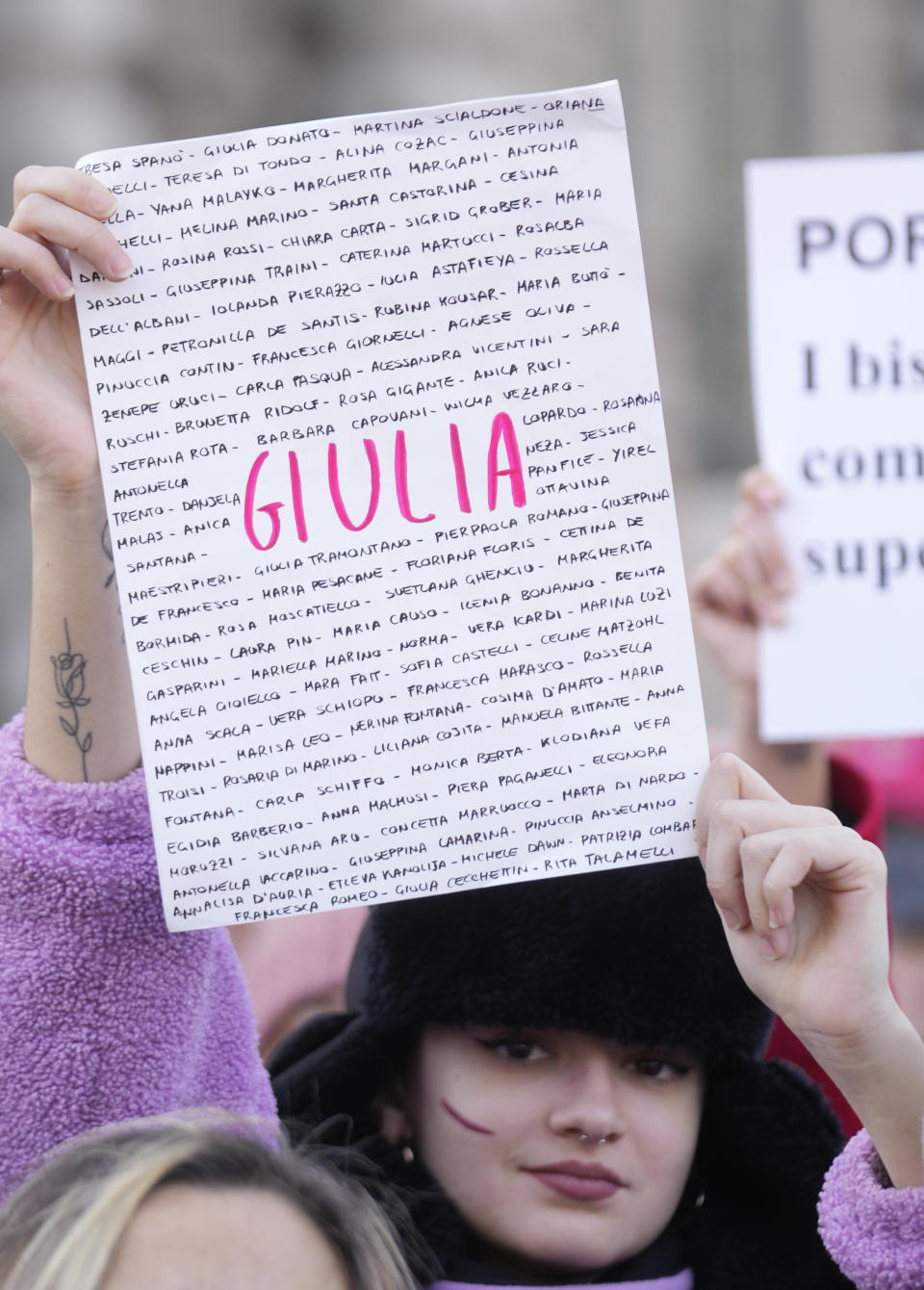 A woman shows a banner bearing the names of femicide victims on the occasion of International Day for the Elimination of Violence against Women, in Milan, Italy, Saturday, Nov.25, 2023. Thousands of people are expected to take the streets in Rome and other major Italian cities as part of what organizers call a "revolution" under way in Italians' approach to violence against women, a few days after the horrifying killing of a college student allegedly by her resentful ex-boyfriend sparked an outcry over the country's "patriarchal" culture. (AP Photo/Luca Bruno)