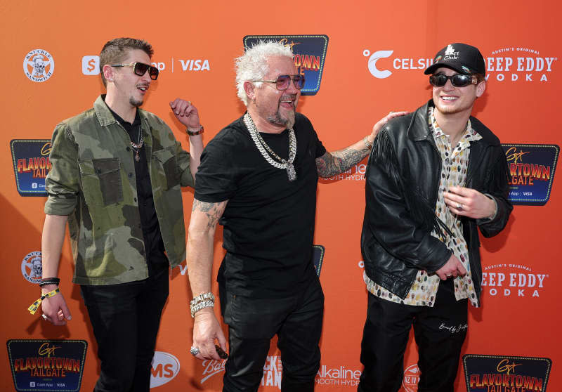 GLENDALE, ARIZONA - FEBRUARY 12: (L-R) Hunter Fieri, Guy Fieri and Jules Fieri arrive at Guy Fieri's Flavortown Tailgate on February 12, 2023 in Glendale, Arizona. (Photo by Ethan Miller/Getty Images)