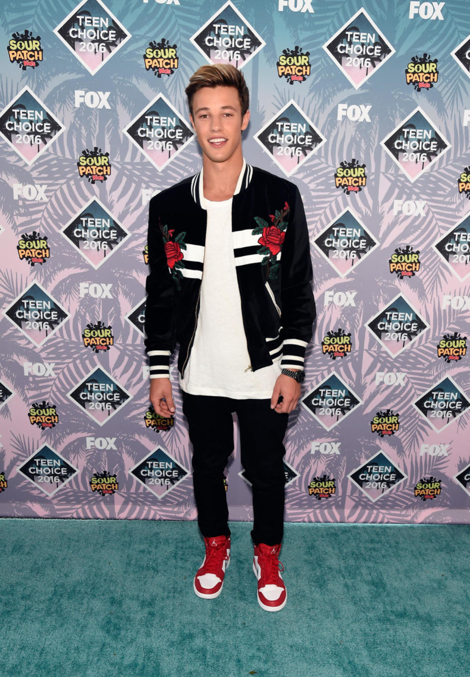 Cameron Dallas in a black-and-white bomber jacket with embroidered roses