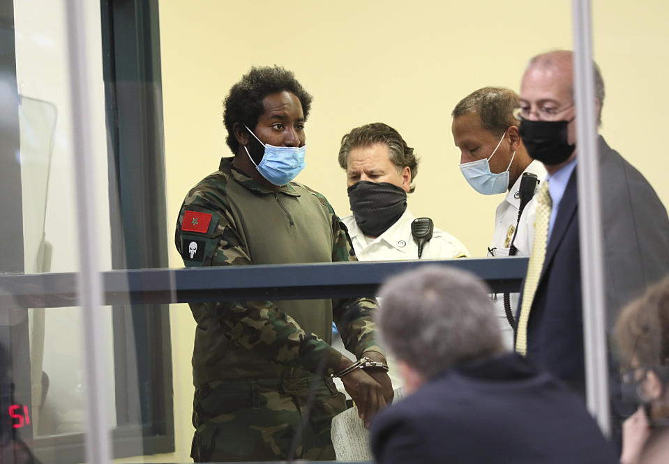 Quinn Cumberlander, left, one of 11 people charged in connection with an armed standoff along a Massachusetts highway last weekend, appears during his arraignment at Malden District Court, Tuesday, July 6, 2021, in Medford, Mass. (Suzanne Kreiter/The Boston Globe via AP, Pool)