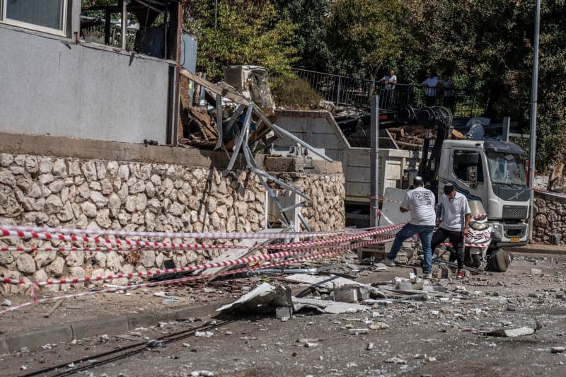 People inspect the damage after a rocket from Lebanon hit a house in Safed. Ilia Yefimovich/dpa