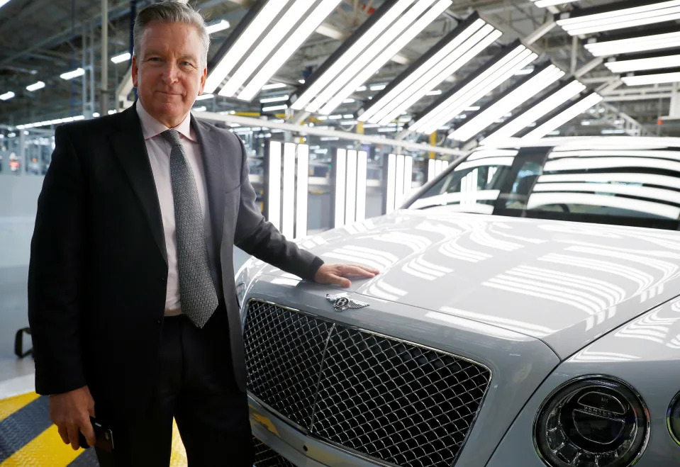 Adrian Hallmark, CEO of Bentley Motors, poses for a photograph next to one of his company's cars on the production line of their factory in Crewe, Britain January 22, 2019. REUTERS/Phil Noble