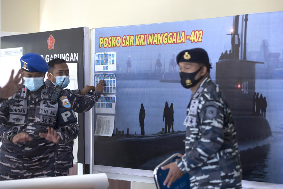 A member of Indonesian military officials sets the pictures of Indonesian Navy submarine KRI Nanggala that went missing while participating in a training exercise on Wednesday, at a command at Ngurah Rai Airport, Bali, Indonesia on Friday, April 23, 2021. Rescuers continued an urgent search Friday for an Indonesian submarine that disappeared two days ago and has less than a day's supply of oxygen left for its crew.(AP Photo/Firdia Lisnawati)