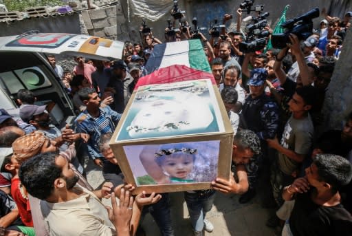 Palestinian mourners carry the coffins of 23-year-old Enas Khammash and her 18-month-daughter Bayan during their funeral in the Gaza Strip on August 9, 2018 after they were killed in an Israeli air strike