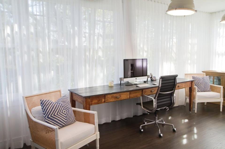 This weathered wooden desk fits perfectly with the other breezy pieces in this Hamptons-style office