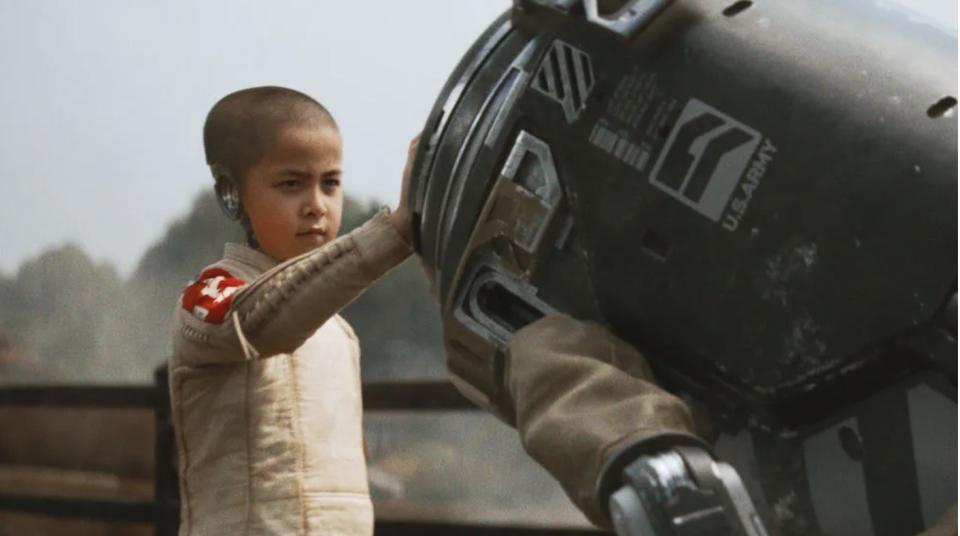 a child with a half-robotic head places his hand on a robot