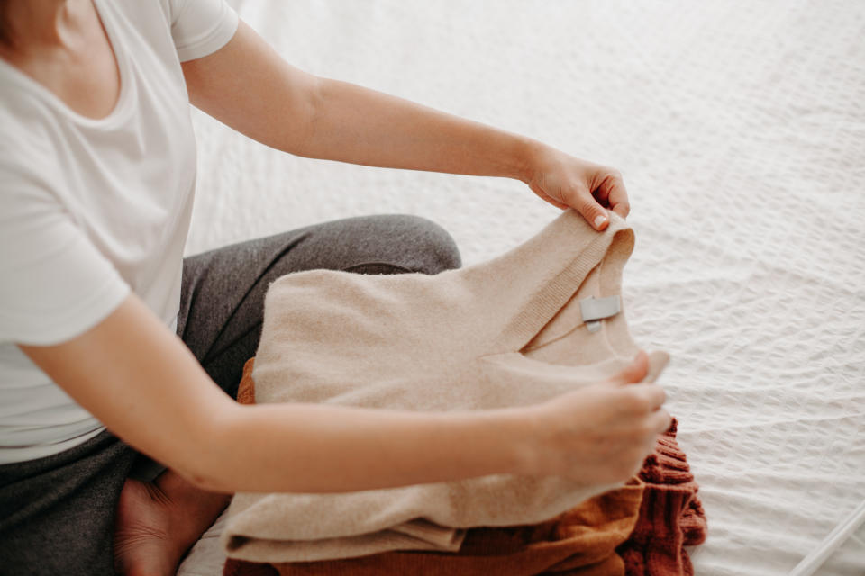 Hands folding a pile of clothes