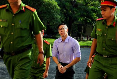 U.S. citizen Will Nguyen is escorted by police before his trial at a court in Ho Chi Minh city, Vietnam July 20, 2018. REUTERS/Stringer