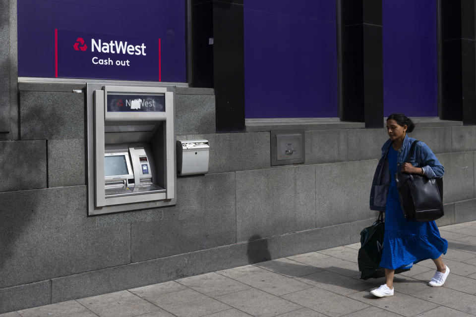NatWest A colourfully dressed woman carrying a shopping bag walks past a cash point, or automated teller machine, baring the logo of major commercial and retail bank NatWest on 15th June, 2022 in Leeds, United Kingdom. (photo by Daniel Harvey Gonzalez/In Pictures via Getty Images)