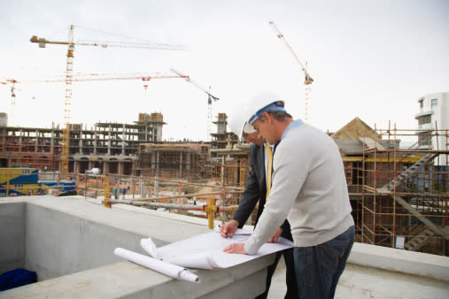 Foreman and co-worker looking at blueprints on construction site