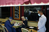 People sit on the terrace of a cafe in Paris, Tuesday, June 2, 2020. Paris City Hall authorized the reopening of outside seating areas but indoor tables remain closed to customers until at least June 22. (AP Photo/Thibault Camus)