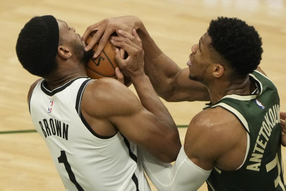 Brooklyn Nets' Bruce Brown and Milwaukee Bucks' Giannis Antetokounmpo battle for the ball during the first half of Game 3 of the NBA Eastern Conference basketball semifinals game Thursday, June 10, 2021, in Milwaukee. (AP Photo/Morry Gash)