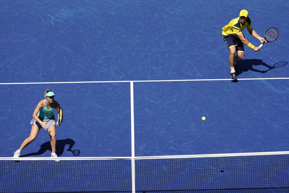 John Peers, right, of Australia, returns a shot as partner Storm Sanders, of Australia, looks on during the mixed doubles final against Kirsten Flipkens, of Belgium, and Edouard Roger-Vasselin, of France, at the U.S. Open tennis championships, Saturday, Sept. 10, 2022, in New York. (AP Photo/Matt Rourke)