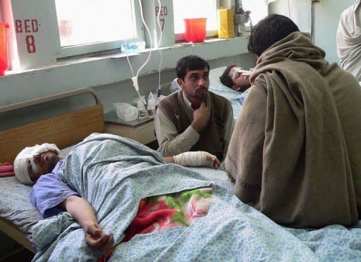 Afghans wounded in the suicide attack receive medical treatment in Jalalabad. A Taliban suicide car bomber targeting NATO troops at an airport in eastern Afghanistan killed nine people Monday, the seventh day of violence over the burning of the Koran at a US airbase