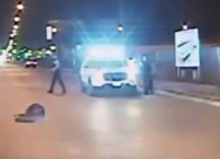 In this screen grab from a video released by the Chicago Police on November 24, 2015, police walk past Laquan McDonald after he was shot by police in Chicago, Illinois on October 24, 2014