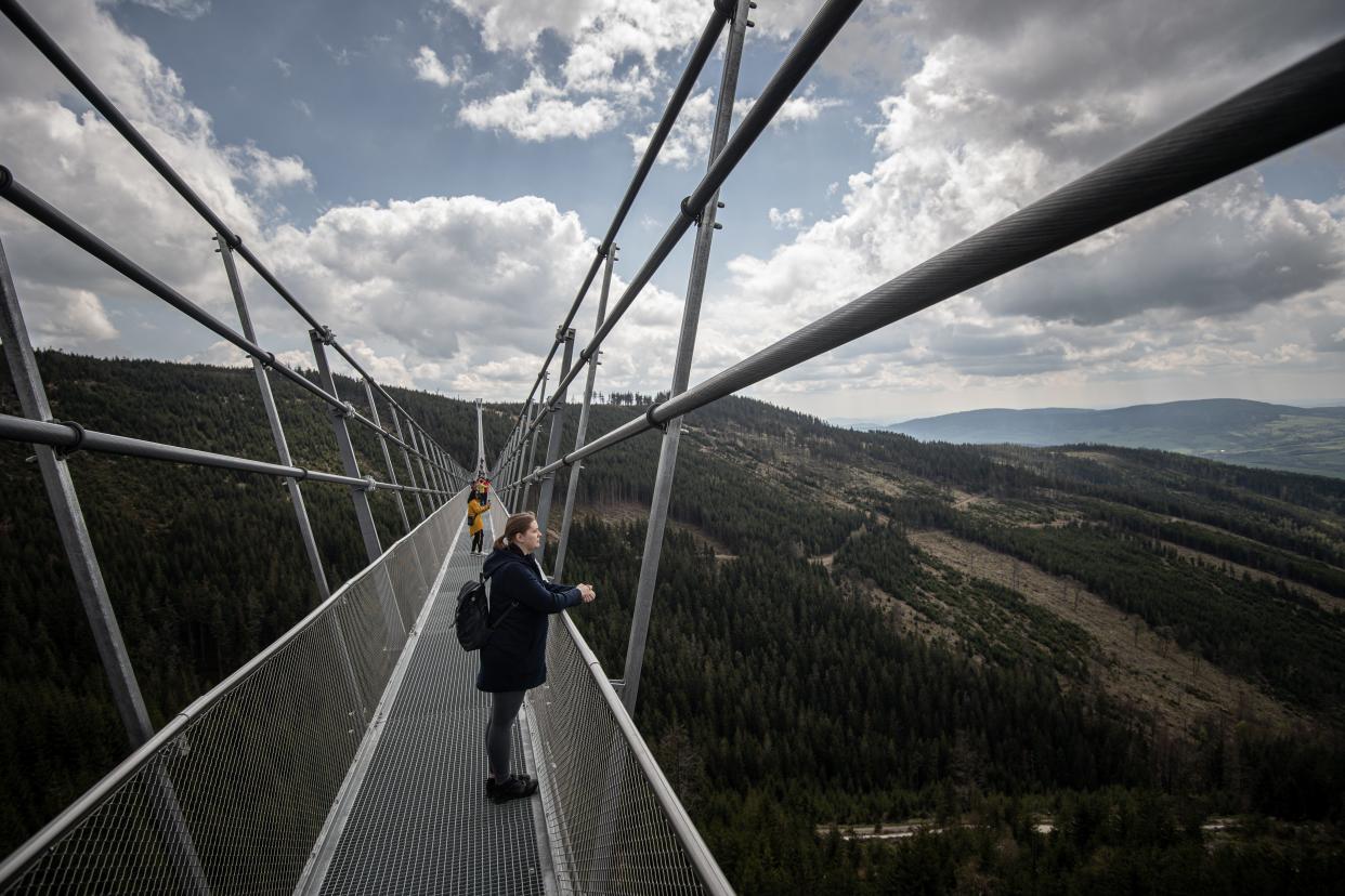 people standing on Sky Bridge 721 in the Czech Republic, the world's longest pedestrian suspension bridge