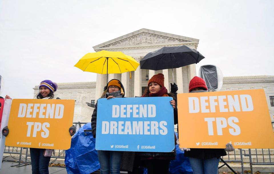 People stand in the cold and rain Tuesday before the U.S. Supreme Court hears arguments on whether the 2017 Trump administration decision to end the Deferred Action for Childhood Arrivals program (DACA) is lawful.