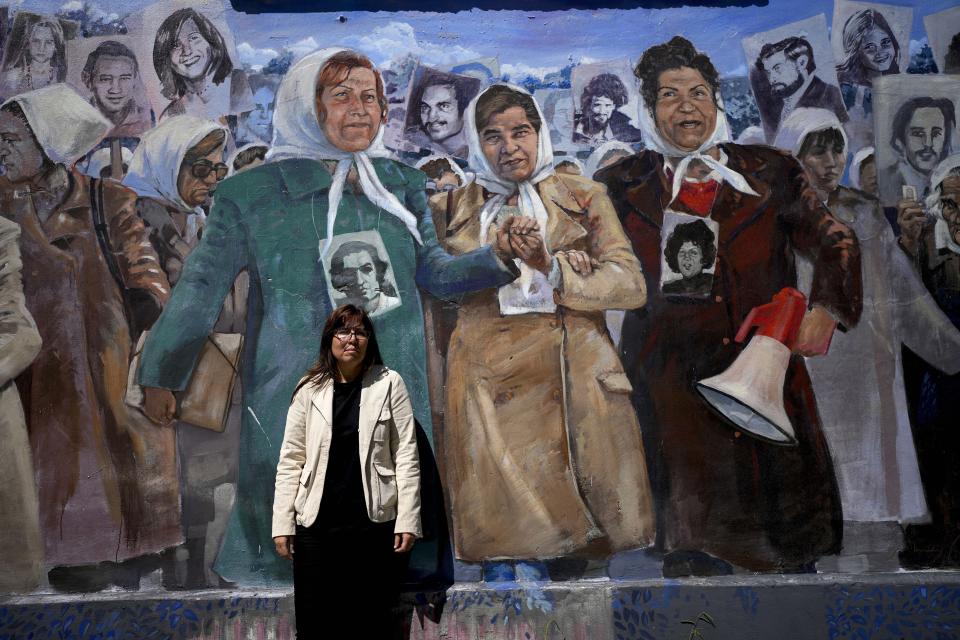 Claudia Poblete poses for a photo in front of a mural depicting the Mothers of Plaza de Mayo group, at the former Navy School of Mechanics, known as ESMA, now a human rights museum, in Buenos Aires, Argentina, Friday, March 22, 2024. Poblete is one of the 133 “recovered grandchildren” of Argentina. Her biological family found her years after she was abducted as an infant during the country’s military dictatorship. (AP Photo/Natacha Pisarenko)