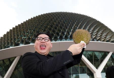 Howard, an Australian-Chinese impersonating North Korean leader Kim Jong Un, poses with a durian at the Esplanade in Singapore May 27, 2018. REUTERS/Edgar Su