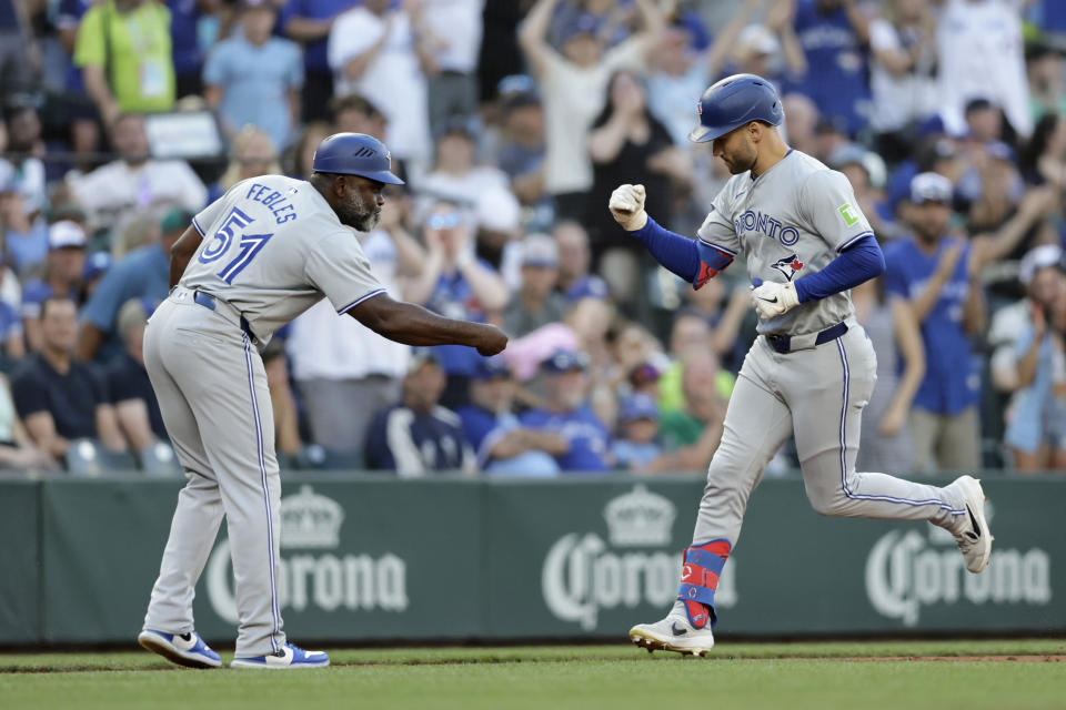 Toronto Blue Jays' Kevin Kiermaier, right, is congratulated by third base coach Carlos Febles, left, after hitting a solo home run on a pitch from Seattle Mariners starter Luis Castillo during a baseball game, Friday, July 5, 2024, in Seattle. (AP Photo/John Froschauer)