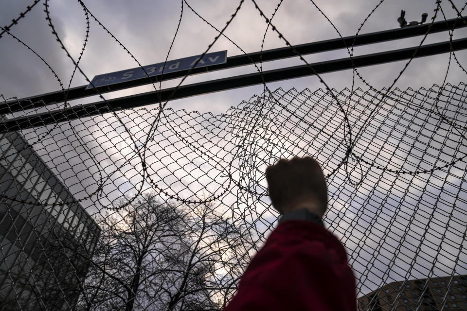 Demonstrators rally outside the Minneapolis 3rd Precinct guarded by perimeter security fences and razor wire as the murder trial against the former Minneapolis police officer Derek Chauvin in the killing of George Floyd advances to jury deliberations, Monday, April 19, 2021, in Minneapolis. (AP Photo/John Minchillo)