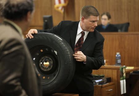 Massachusetts State Police Trooper Todd Girouard, holds a tire as he testifies during the murder trial of former New England Patriots football player Aaron Hernandez in Fall River, Massachusetts, March 5, 2015. REUTERS/Steven Senne/Pool