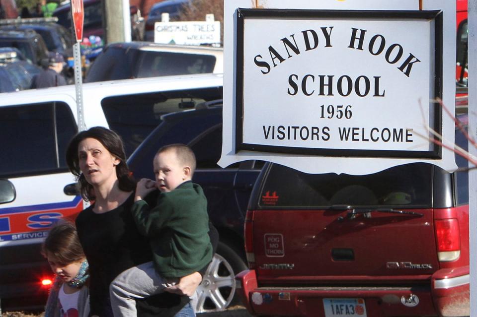A parent walks away from Sandy Hook Elementary School with her children following the shooting in 2012 (AP)