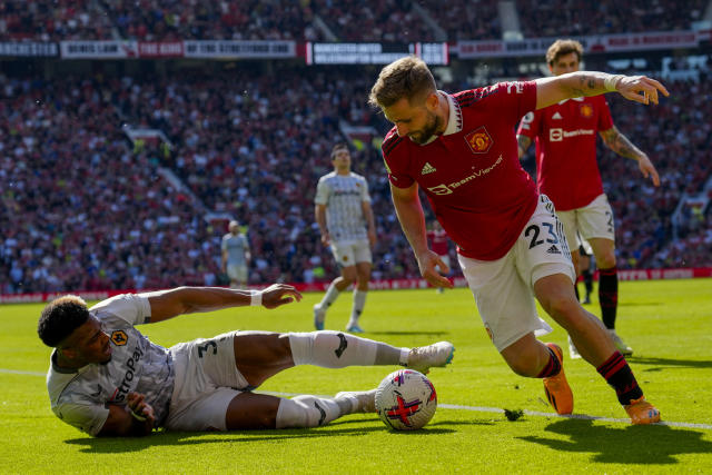 Manchester United's Luke Shaw, right, duels for the ball with Wolverhampton Wanderers' Adama Traore during the English Premier League soccer match between Manchester United and Wolverhampton at the Old Trafford stadium in Manchester, England, Saturday, May 13, 2023. (AP Photo/Jon Super)