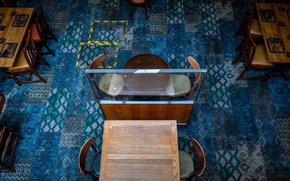 A perspex screen divides tables as part of social distancing measures at The Mossy Well pub, operated by J D Wetherspoons  - Chris J. Ratcliffe/ Bloomberg