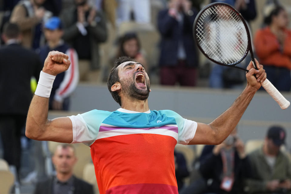 Croatia's Marin Cilic celebrates winning his quarterfinal match against Russia's Andrey Rublev in five sets, 5-7, 6-3, 6-4, 3-6, 7-6 (10-2), at the French Open tennis tournament in Roland Garros stadium in Paris, France, Wednesday, June 1, 2022. (AP Photo/Michel Euler)