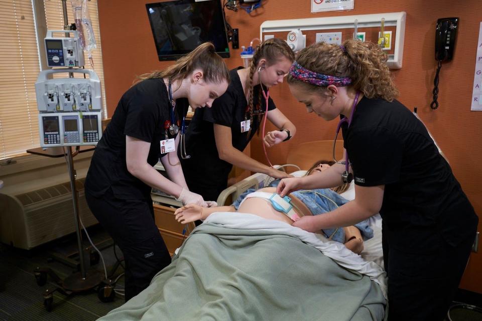 Three nursing students at Gardner-Webb University practice their skills during a class session.
