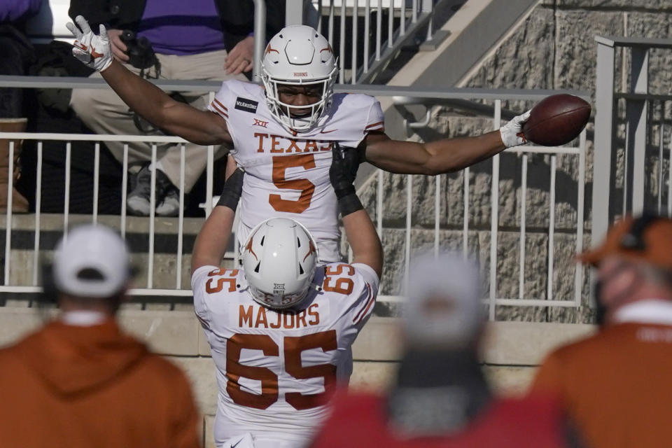 Texas running back Bijan Robinson (5) celebrates a touchdown with teammate Jake Majors (65).