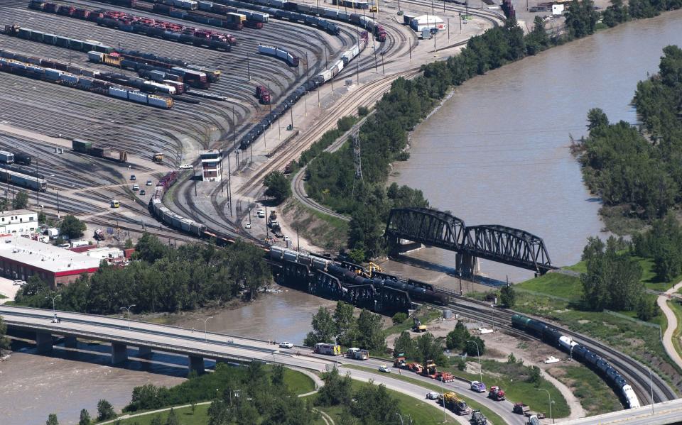 <p> Crews work at the scene of a rail bridge collapse and railcars derailment over the Bow River, southeast of downtown Calgary, Canada on Thursday, June 27, 2013. (AP Photo/The Canadian Press, Larry MacDougal)</p>