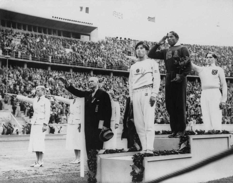 FILE - In this Aug. 11, 1936, file photo, America's Jesse Owens, second from right, salutes during the presentation of his gold medal for the long jump, after defeating Nazi Germany's Lutz Long, right, during the 1936 Summer Olympics in Berlin. Naoto Tajima of Japan, center, placed third. The performance of Jesse Owens will be honored in the stadium where he won four gold medals at the 1936 Olympic Games when the world championships are held in Berlin this month. (AP Photo/File)