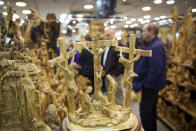 In this Thursday, Dec. 6, 2018 photo, people visit a shop near the Church of the Nativity, built atop the site where Christians believe Jesus Christ was born, in the West Bank City of Bethlehem. City officials are optimistic that the renovated church will help add to a recent tourism boom and give a boost to the shrinking local Christian population. (AP Photo/Majdi Mohammed)