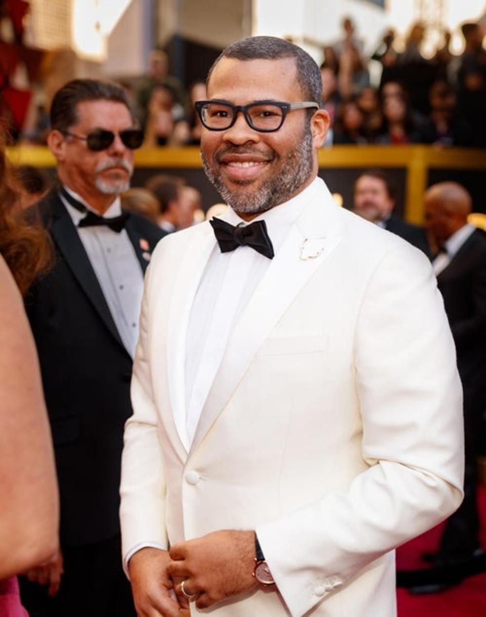 Director Jordan Peele dressed in a Calvin Klein white suit for the 90th Annual Academy Awards. He accessorized the look wtih a Montblanc watch and Jason of Beverly Hills lapel pin. (Getty)
