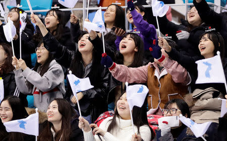 Ice Hockey - Pyeongchang 2018 Winter Olympics - Women’s Classification Match - Sweden v Korea - Kwandong Hockey Centre, Gangneung, South Korea - February 20, 2018 - Fans holding unification flags cheer before the game. REUTERS/David W Cerny