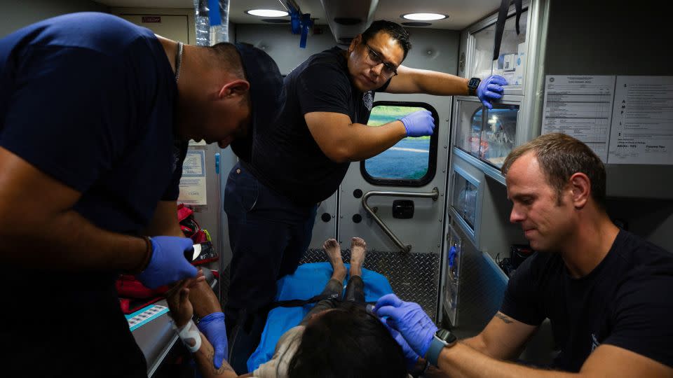 A firefighter EMT team treats a migrant woman suffering from heat exhaustion in the border community of Eagle Pass, Texas, U.S. June 26, 2023.  - Kaylee Greenlee Beal/Reuters