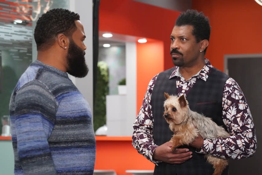 Anthony Anders, left, and Deon Cole, holding a small dog, in "black-ish" on ABC.