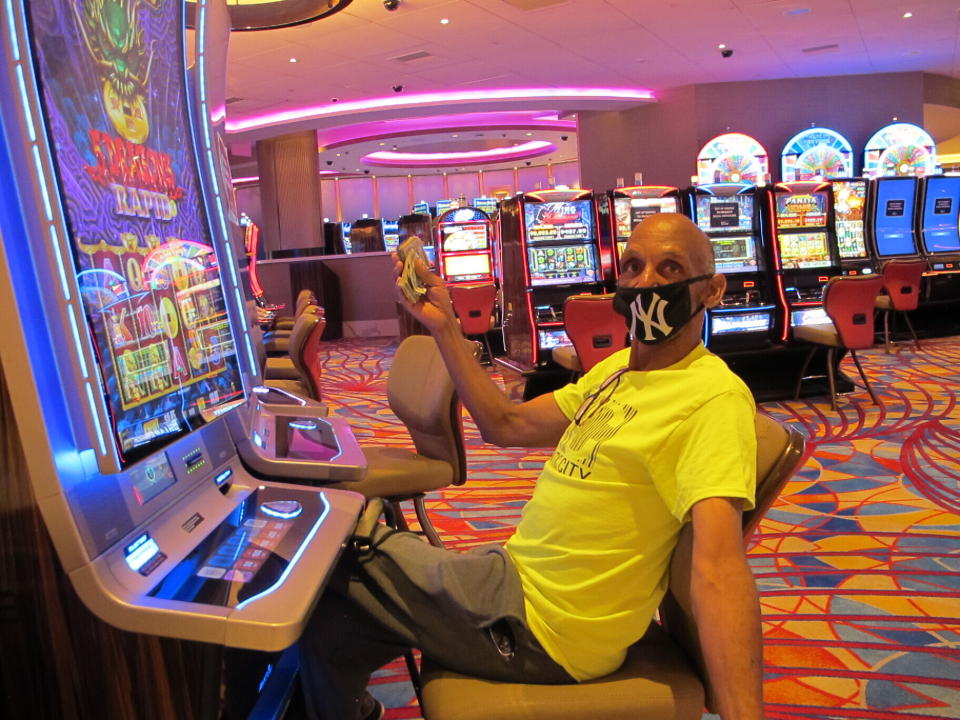 Gary Royster of Atlantic City holds up a wad of cash he used to gamble at the Hard Rock casino in Atlantic City on July 2, 2020, the day the casino reopened after being shut down for months amid the coronavirus outbreak. New Jersey's casinos and horse tracks won $264.5 million in July after reopening amid the coronavirus outbreak, a figure that was down nearly 21% from a year ago, but one the gambling houses will gladly take after months of inactivity. (AP Photo/Wayne Parry)