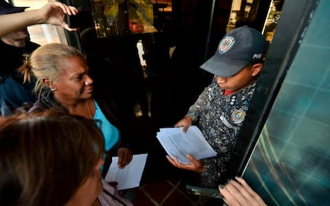 Supporters of Mr Guaido took amnesty letters to military posts on Sunday in a bid to persuade soldiers to come over to his side - Credit: Luis Robayo/AFP