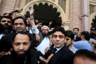 Hafiz Saeed (C) reacts to supporters as he walks out of court after a Pakistani court ordered his release from house arrest in Lahore, Pakistan November 22, 2017. REUTERS/Mohsin Raza