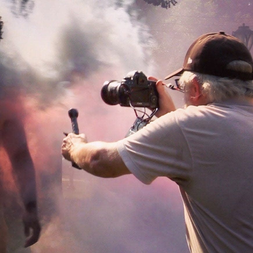 The Journal News/lohud photojournalist Peter Carr shooting smoky Super 11 football photos.