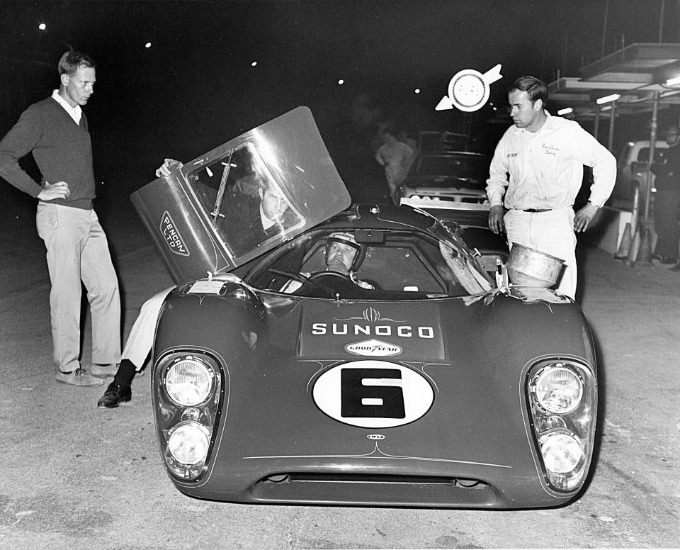 At the 1969 24 Hours of Daytona, Mark Donohue (in cockpit) sits in the pits while Roger Penske opens the door for a discussion. Donohue and co-driver won that year's 24 Hours in a Penske-prepared Lola.