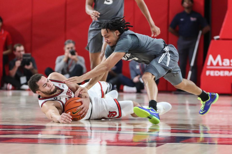 Dec 20, 2023; Queens, New York, USA; St. John's Red Storm guard Chris Ledlum (8) and Xavier Musketeers guard Trey Green (0) fight for a loose ball in the first half at Carnesecca Arena.