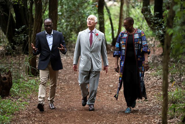 <p>Pool - Phil Noble/Getty</p> King Charles walks with a government official and Wanjira Mathai in the the Karura urban forest on November 1.