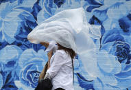 <p>A woman puts on a plastic cover before the 144th running of the Kentucky Derby horse race at Churchill Downs Saturday, May 5, 2018, in Louisville, Ky. (Photo: Jeff Roberson/AP) </p>