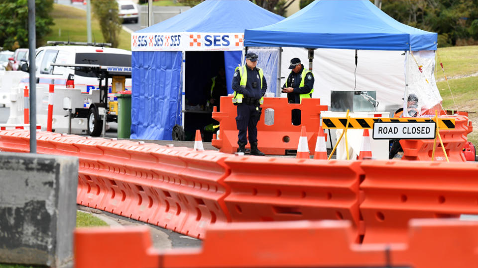 Police officers are seen at a checkpoint on the Queensland-New South Wales border in Coolangatta on the Gold Coast, Thursday, July 23, 2020