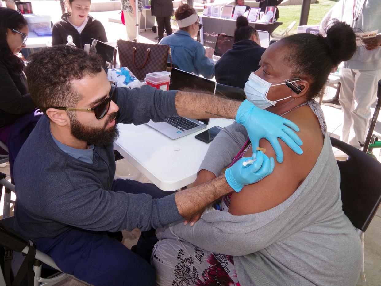 Forristean Gomes of Brockton, Massachusetts, gets a COVID-19 vaccine booster shot from a staff medical technician from East Coast Clinical Health Center. The vaccination came during 1st Responders Appreciation Day in Brockton on Sept. 27.